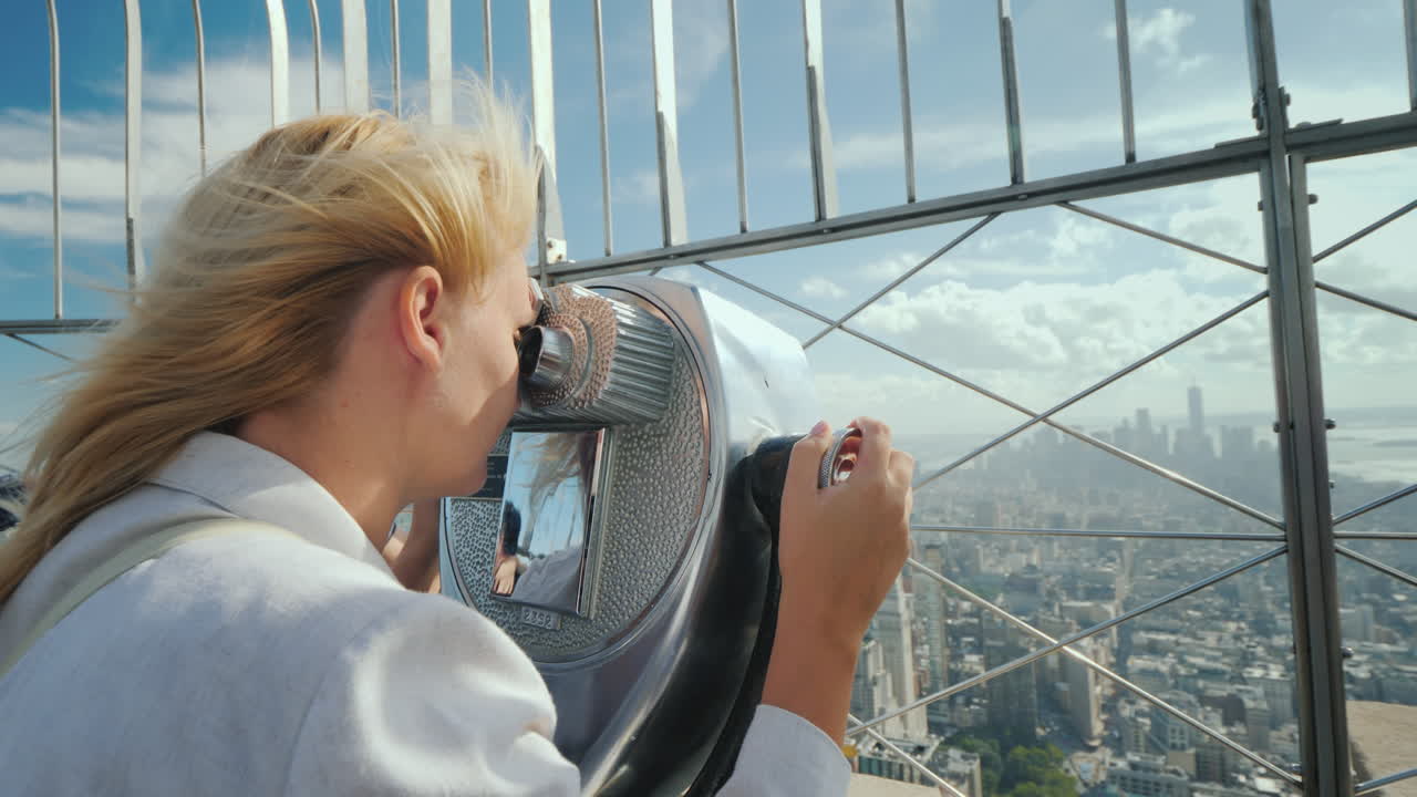 mujer rubia mirando a través de binoculares en el panorama de nueva york visite el concepto de nueva york