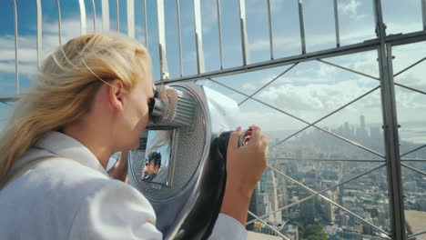 Blonde-Frau,-Die-Durch-Ein-Fernglas-Auf-Das-Panorama-Von-New-York-Schaut,-Besuchen-New-York-Concept