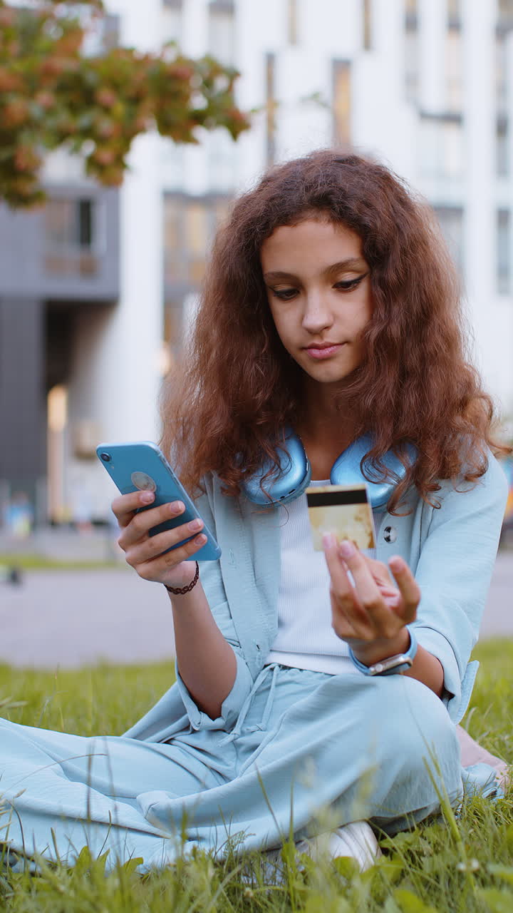 Preteen girl using credit bank card smartphone while transferring money purchases online shopping