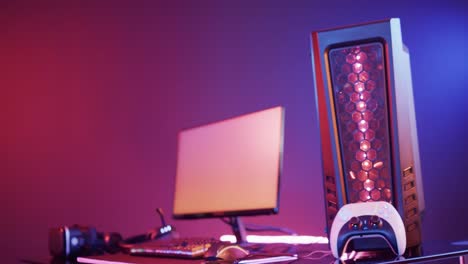 Video-of-computer-and-gaming-equipment-on-desk-with-copy-space-on-neon-background