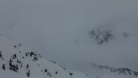 Time-lapse-of-clouds-swirling-around-snow-covered-mountain-tops