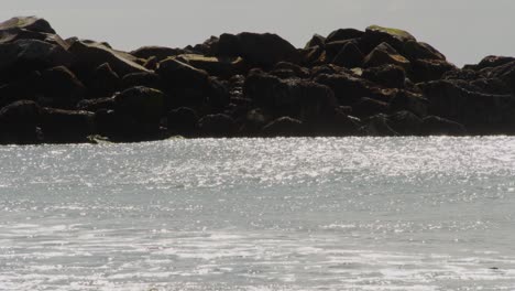 viento fuerte que sopla contra olas que chocan haciendo que las partículas de agua vuelen hacia atrás, vista estática