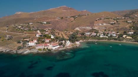 Tilt-down-aerial-towards-houses-and-church-nex-to-beautiful-ocean-on-Greek-Island