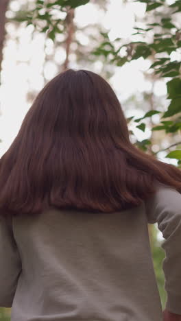atleta femenina corriendo a través del bosque en un tiempo soleado. joven se prepara para competiciones realizando ejercicios físicos en la naturaleza en un día de verano