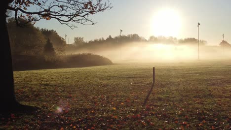 Vista-Aérea-Mañana-Brumosa-Campo-De-Rugby-De-Otoño-Durante-El-Vibrante-Amanecer-Dorado-Y-Brillante