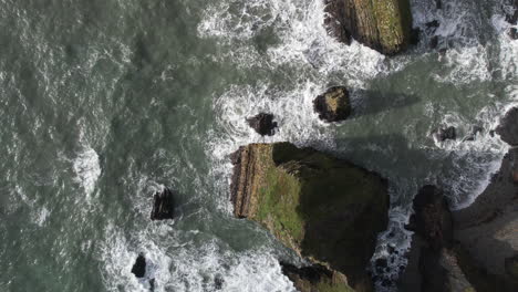 Top-Down-Aerial-View-of-Sea-Waves-Breaking-on-Cliffs-of-Ireland's-Coast