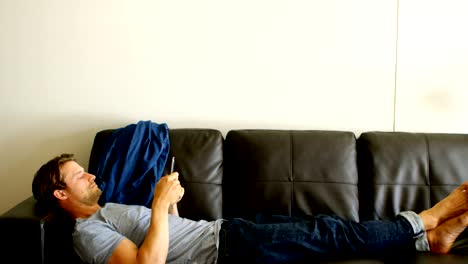 hombre usando teléfono móvil en la sala de estar 4k