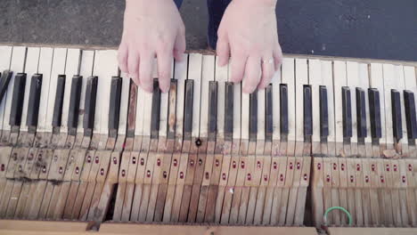 Top-Down-Shot-of-Old-Chipped,-Rotting-Piano-Being-played-by-White-Woman