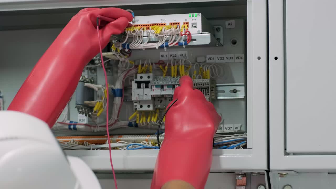 el ingeniero eléctrico que trabaja comprueba la tensión de corriente eléctrica y la sobrecarga en la parte delantera del gabinete del centro de carga o de la unidad de consumo para el mantenimiento en la sala principal del sistema de distribución de energía.