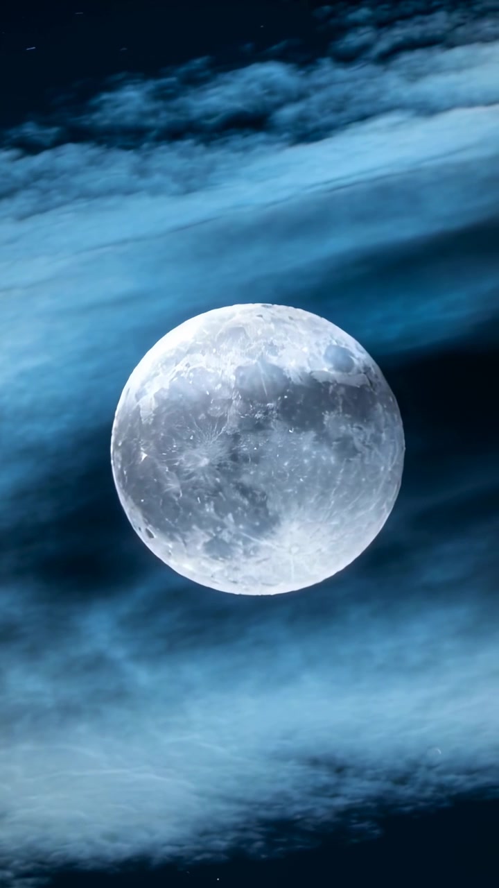 Vídeo vertical: Faixas de nuvens impulsionadas pelo vento flutuando cruzando a lua cheia no céu noturno, revelando crateras