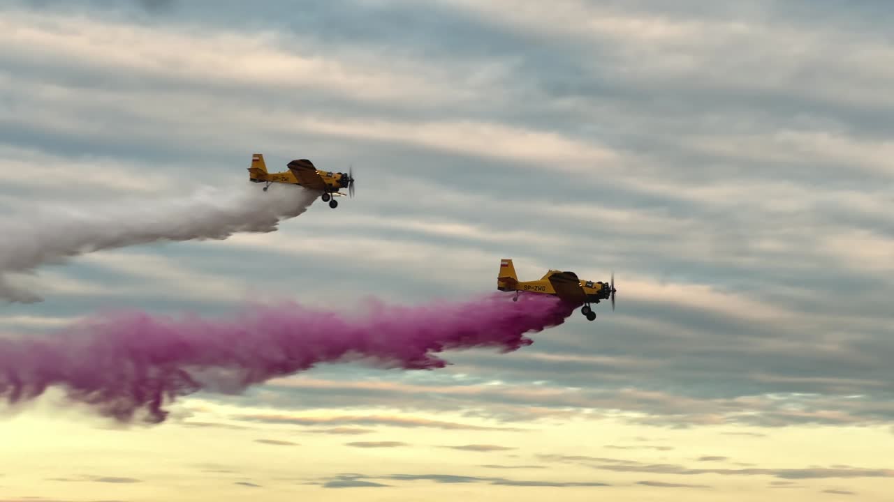 Two M18 Dromedary aircraft execute a synchronized low pass with water release at an airshow. Ideal for aviation, precision flying, and aerial display themes. Highlights power and control