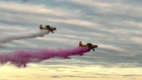 two m18 dromedary aircraft execute a synchronized low pass with water release at an airshow. ideal for aviation, precision flying, and aerial display themes. highlights power and control