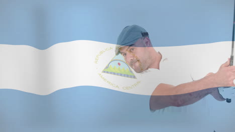 mid adult man gripping silver bat over nicaraguan flag, showing baseball swing education graphics