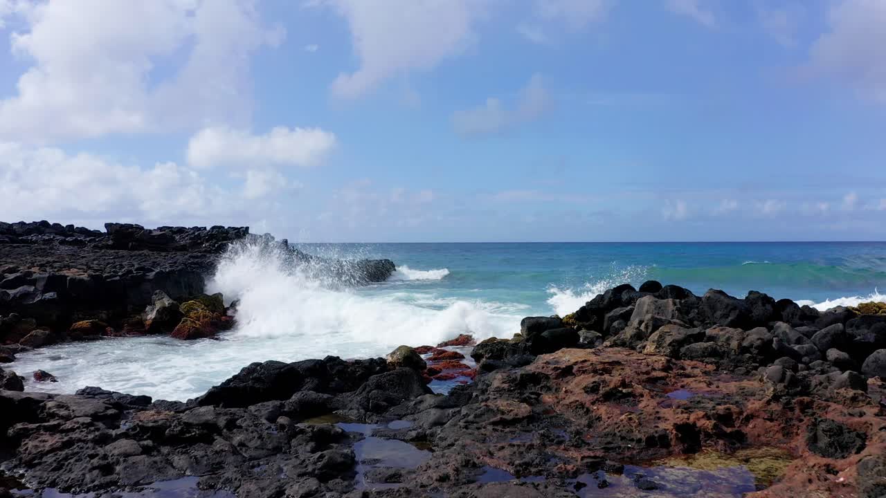 Slow motion push in cinematic aerial drone shot in 4K filmed on Brennecke's Beach in Kauai, Hawaii