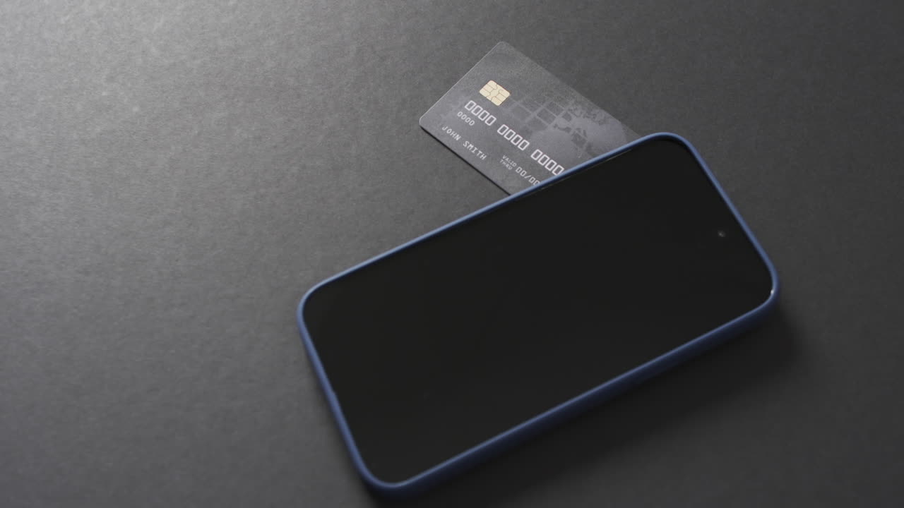 Video of smartphone with blank screen, boxes and credit card with copy space on grey background