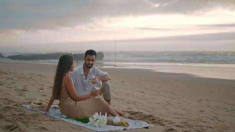 Affectionate-pair-talking-picnic-sea-vertical.-Family-celebrating-anniversary