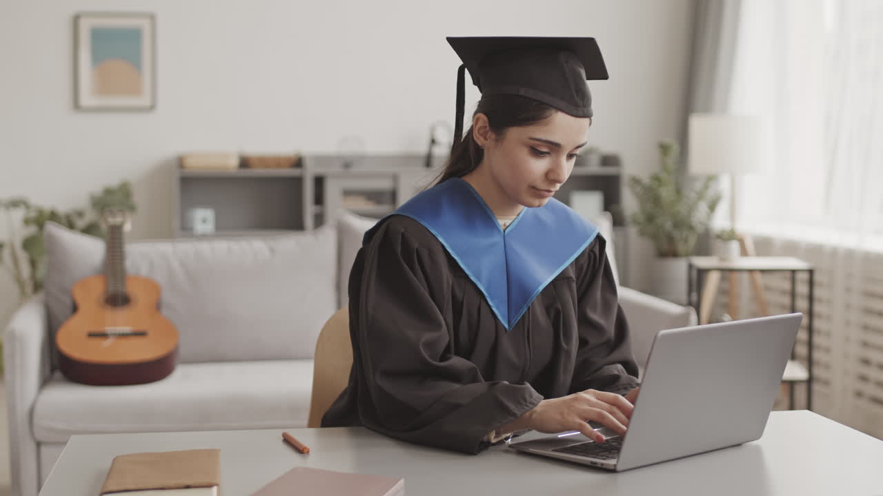 Female Graduate Using Laptop at Home