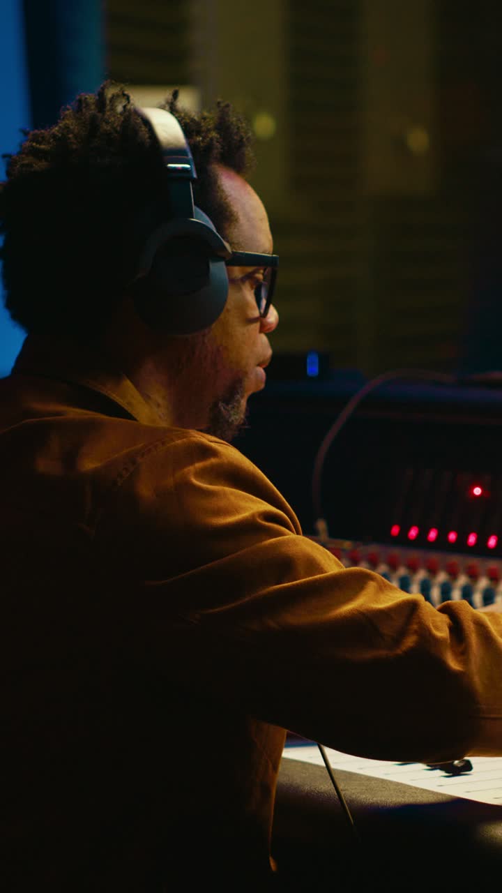 Focused Music Producer Working on an Audio Mixing Console