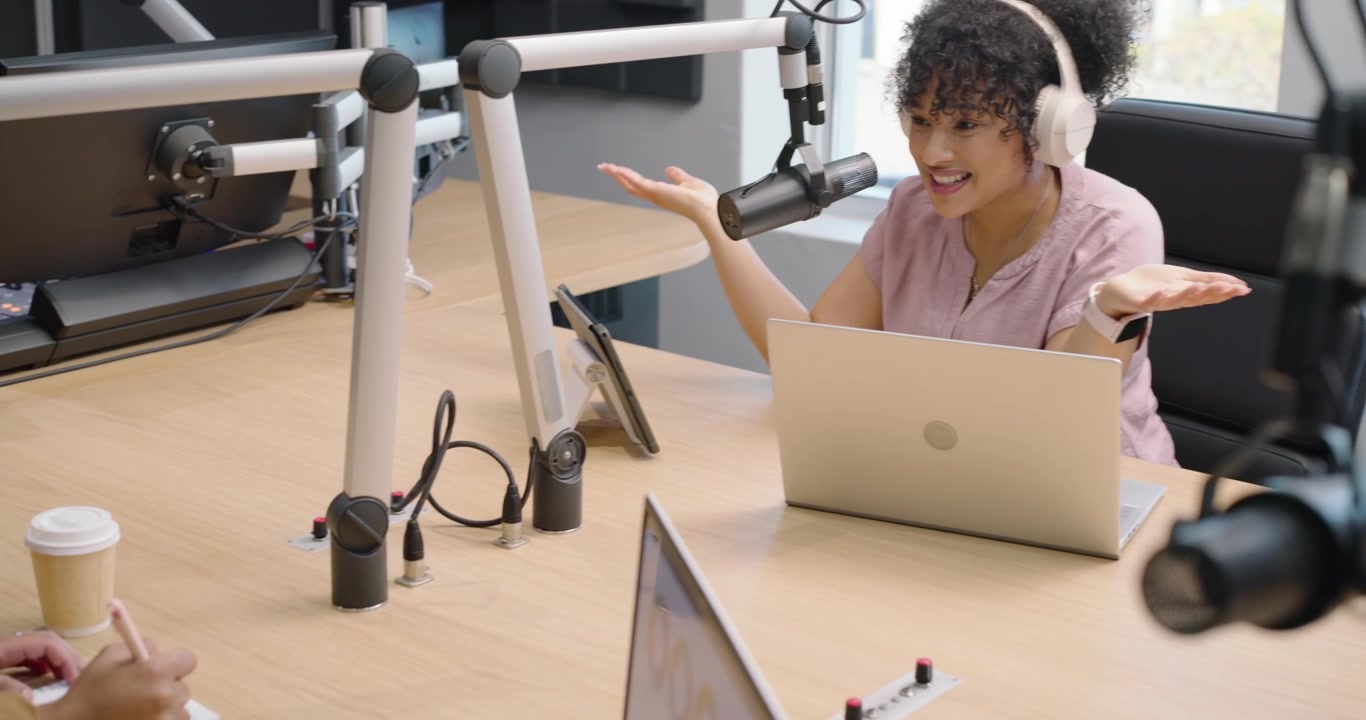 Anfitriões afro-americanos começando a gravar no estúdio, mulher inclinada sobre o microfone boom gravando um episódio.