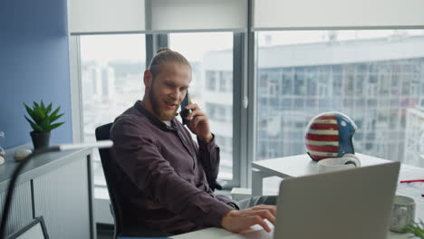 Happy-man-calling-telephone-at-office-close-up.-Millennial-manager-consulting