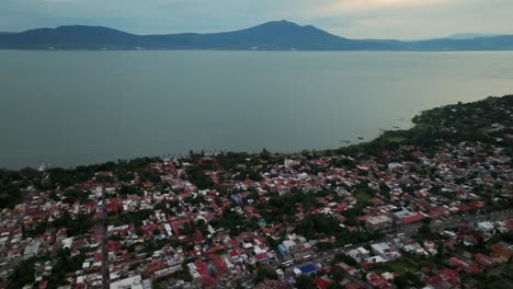 aerial view of a town by a lake with mountains in the background