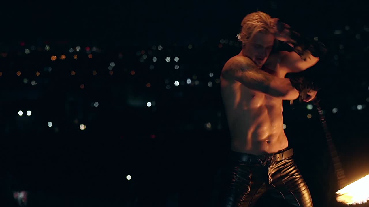 joven hombre rubio gira dos antorchas ardientes poi en cadena cámara lenta disparado de cerca