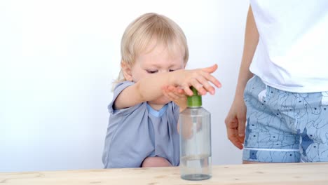 toddler learning to wash hands with adult supervision