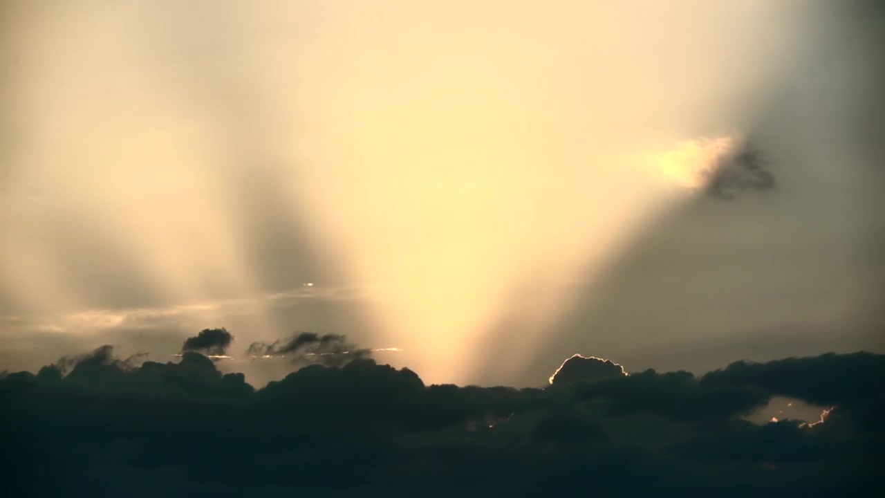 Raggi di sole che filtrano attraverso nuvole scure al tramonto