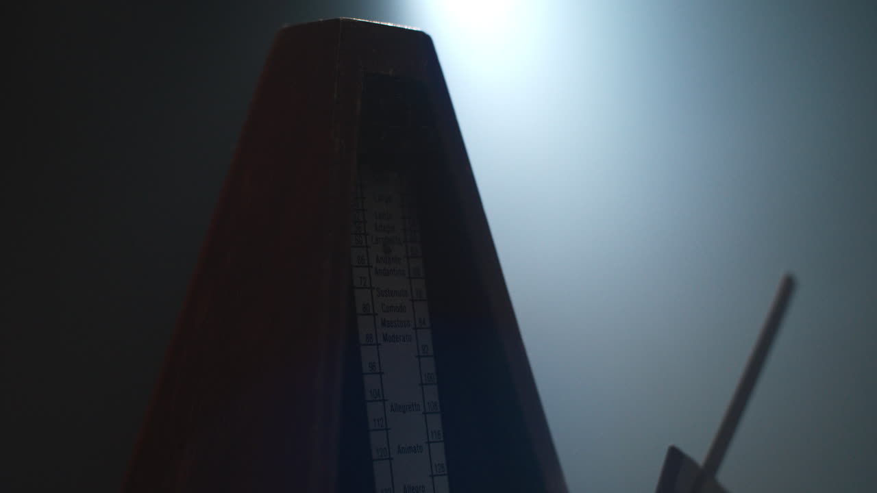 Metronome set the rythm in the dark, old room