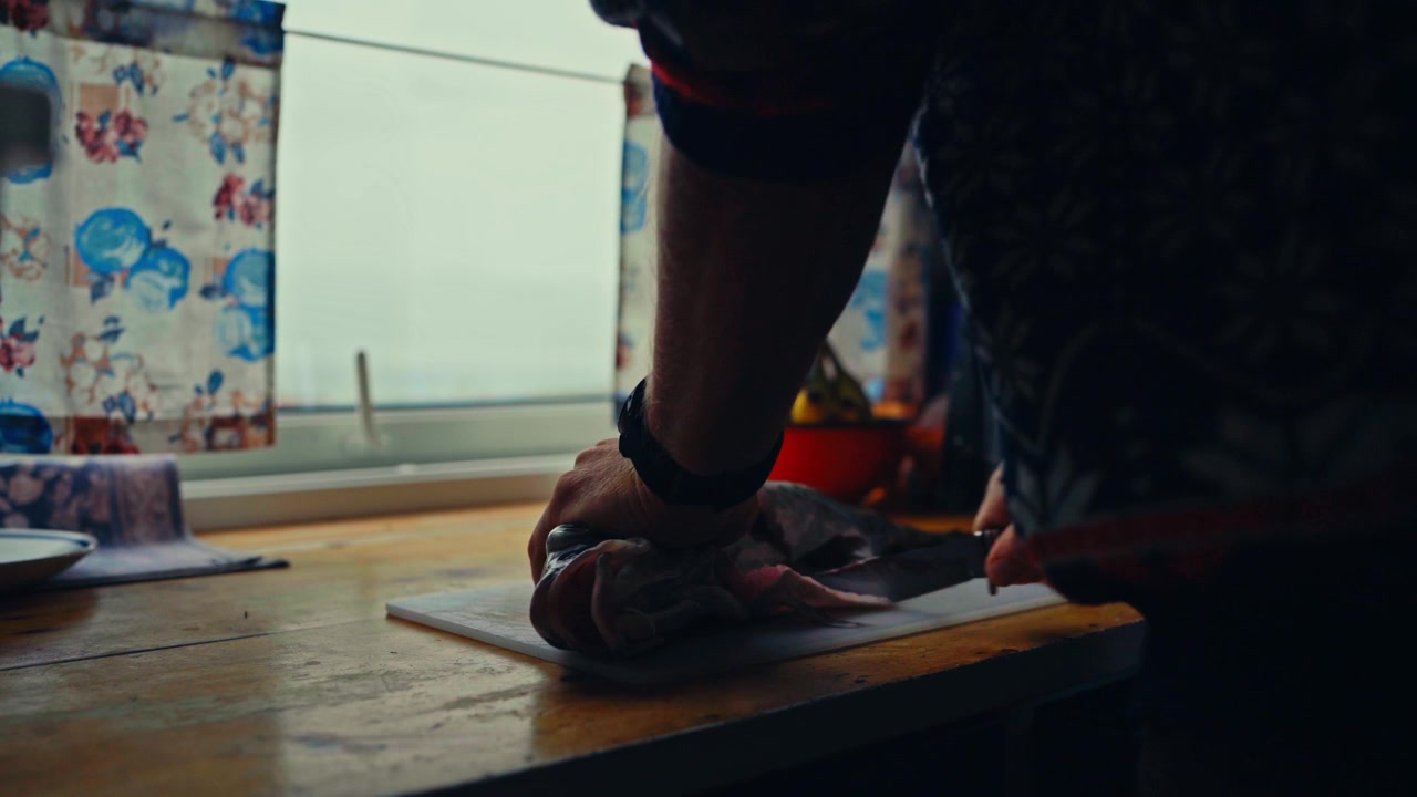 Man Cutting Freshly Caught Fish In The Kitchen - Close Up