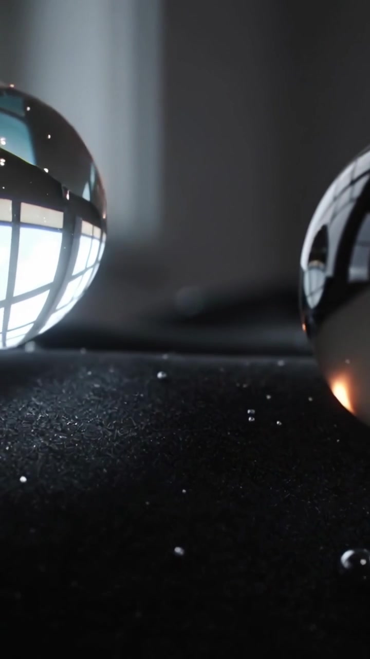 Vertical video: Shifting camera drawing glass spheres on velvet, showing pane glare and droplets