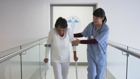 joven médico ayudando al paciente a usar muletas en el hospital 4k