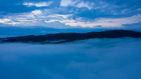 drone shot of moving inversion clouds just below the mountains