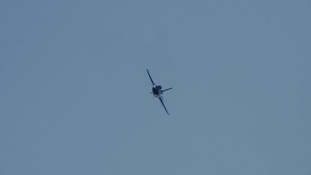 Caccia militare F-16 in volo e in manovra in un cielo azzurro e limpido