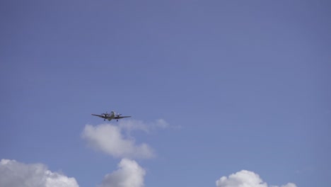 filmación de tiro de virada de un avión bimotor volando bajo un cielo azul