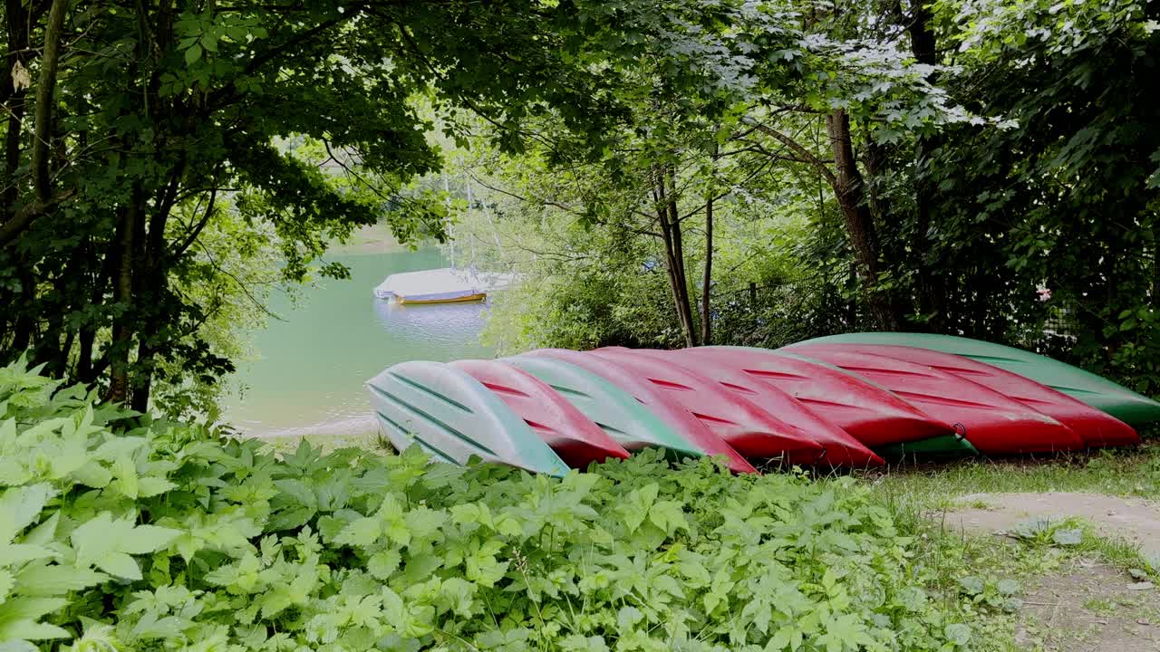Red canoes lie upside down at the lake on the banks of the agger dam