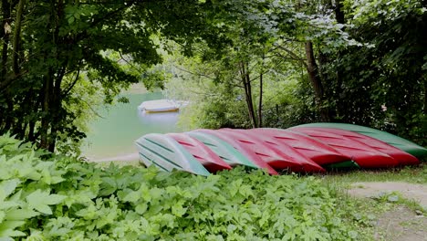 Red-canoes-lie-upside-down-at-the-lake-on-the-banks-of-the-agger-dam