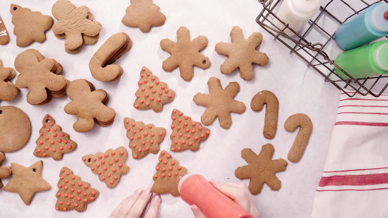 decorando galletas de pan de jengibre con glaseado real para navidad.