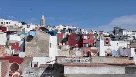 Urban rooftops in Tangier, Morocco, with satellite dishes and clear blue skies