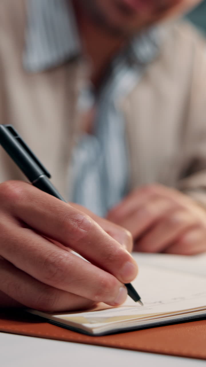 Close-Up of Person's Hand Writing in a Notebook