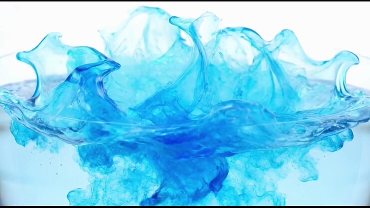 Goccia d'inchiostro blu che si dissolve e si diffonde in acqua limpida