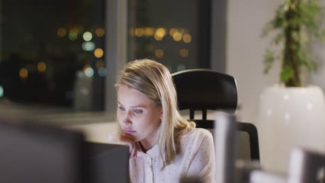 Professional-businesswoman-working-while-sitting-on-her-desk-in-modern-office-in-slow-motion