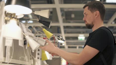 hombre comprando lámparas de mesa en una tienda