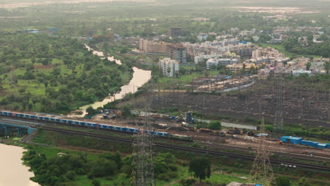 freight train traveling through lush green countryside, aerial view, indian railways