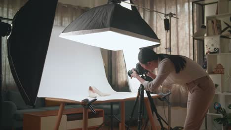 asian female photographer being tired taking photos of women's shoes in home studio