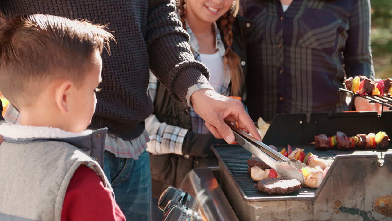 Famiglia che fa un barbecue su una terrazza nel bosco, primo piano