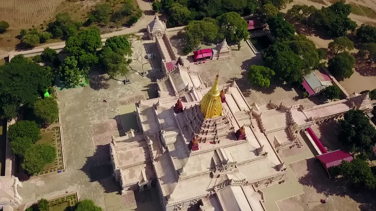 A stunning pull-out aerial reveal of the White Temple at Ananda Temple in Bagan, Myanmar, showcasing the magnificent golden Sertok and the temple's intricate architecture and spiritual significance.