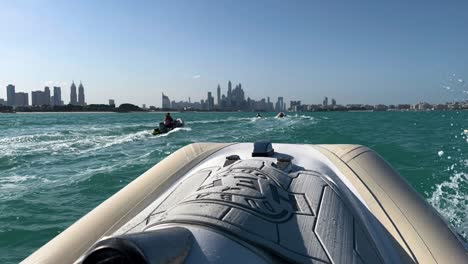 Speedboat-Tour-And-Sightseeing-Across-The-Persian-Gulf-In-Dubai,-UAE-With-Skyline-In-Distant-Background