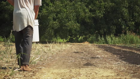 Close-up-in-slow-motion-of-a-person-fertilizing-farm-ground-with-powdered-fertilizer