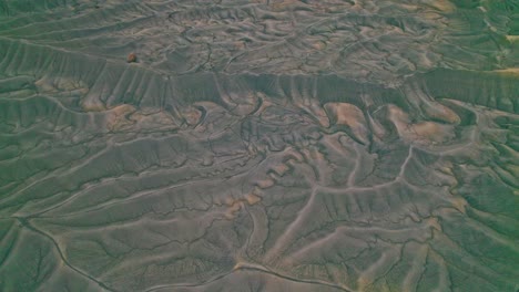 drone view of utah’s factory butte with rugged terrain, reosion patterns, striated slopes, sedimentary layers, and stark desert geology in 4k.
